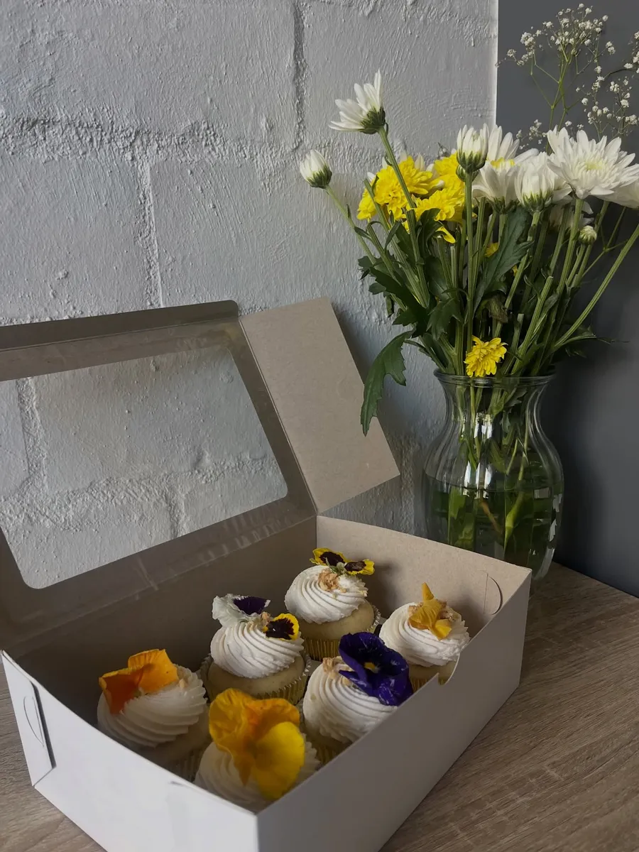 Box of cupcakes topped with edible pansies